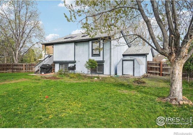 13755 W 65th Dr, Arvada, CO 80004 - back of property with a fenced backyard, a storage shed, and roof with shingles