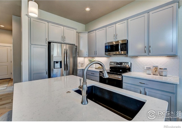 208 High Point Dr, Longmont, CO 80504 - kitchen with appliances with stainless steel finishes, light stone counters, decorative backsplash, recessed lighting, and gray cabinets