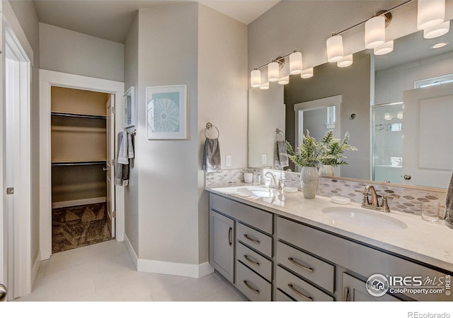 208 High Point Dr, Longmont, CO 80504 - bathroom with a spacious closet, double vanity, a shower stall, tile patterned flooring, and baseboards