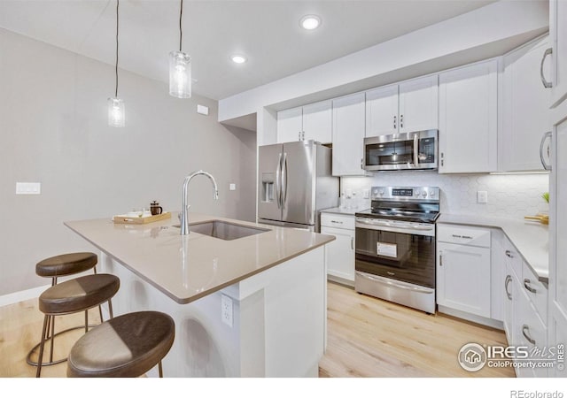 968 Birdwhistle Ln Unit 6, Fort Collins, CO 80524 - kitchen featuring appliances with stainless steel finishes, a sink, light wood-style flooring, backsplash, and recessed lighting