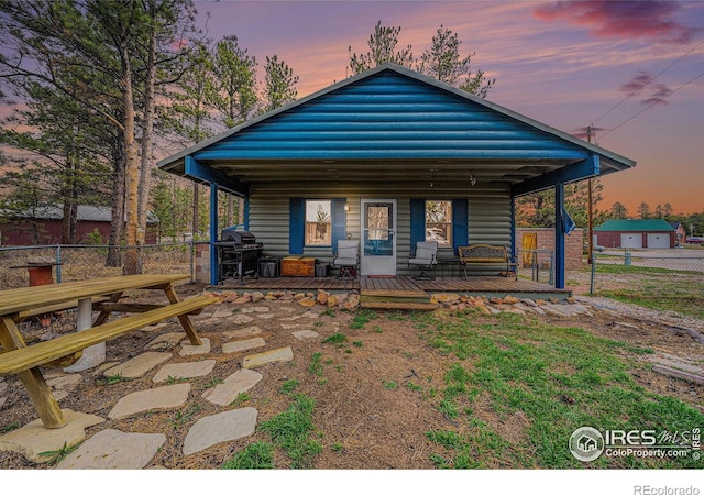 95 Eagle Tree Cir, Red Feather Lakes, CO 80545 - back of house at dusk with covered porch and fence