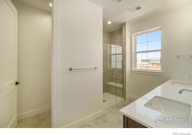 full bathroom with a stall shower, baseboards, double vanity, and recessed lighting