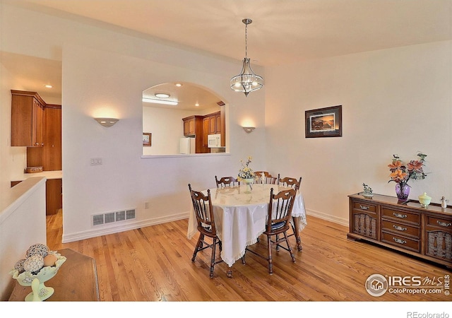 355 47th Ave Unit A, Greeley, CO 80634 - dining area with a notable chandelier, arched walkways, baseboards, light wood-type flooring, and visible vents