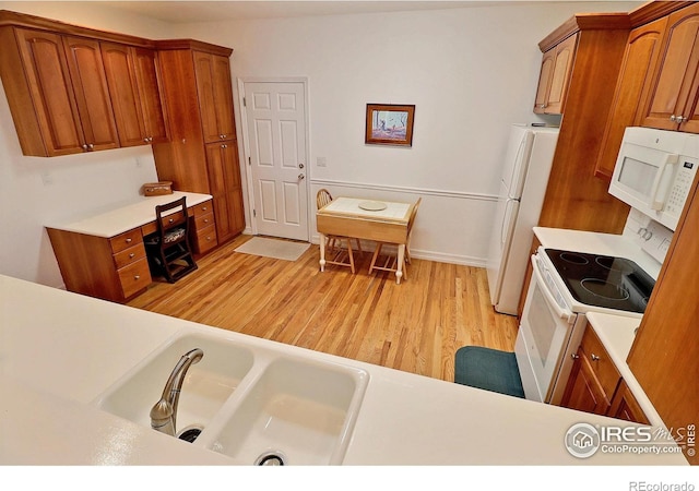 355 47th Ave Unit A, Greeley, CO 80634 - kitchen featuring light countertops, light wood-style flooring, brown cabinets, and white appliances