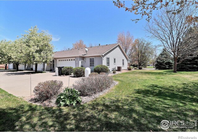 355 47th Ave Unit A, Greeley, CO 80634 - view of side of home with a lawn, stucco siding, an attached garage, central air condition unit, and driveway