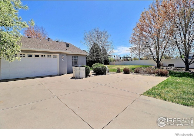 355 47th Ave Unit A, Greeley, CO 80634 - view of home's exterior with a yard, fence, concrete driveway, an attached garage, and stucco siding