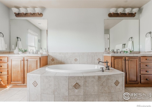 full bath with tile patterned floors, a garden tub, and two vanities