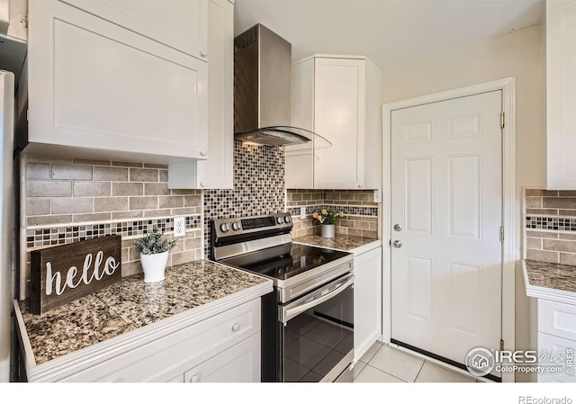 1352 S Terry St, Longmont, CO 80501 - kitchen with electric range, wall chimney range hood, white cabinetry, tasteful backsplash, and light tile patterned floors