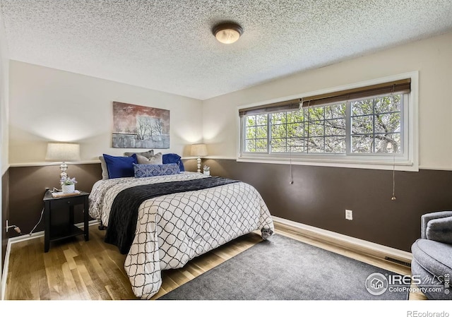1352 S Terry St, Longmont, CO 80501 - bedroom featuring visible vents, baseboards, a textured ceiling, and wood finished floors