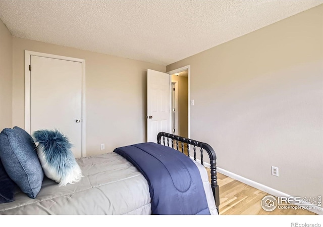 1352 S Terry St, Longmont, CO 80501 - bedroom with a textured ceiling, baseboards, wood finished floors, and a closet