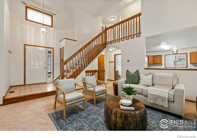 2476 Forsythia Dr, Loveland, CO 80537 - living room featuring stairway, baseboards, arched walkways, and a towering ceiling