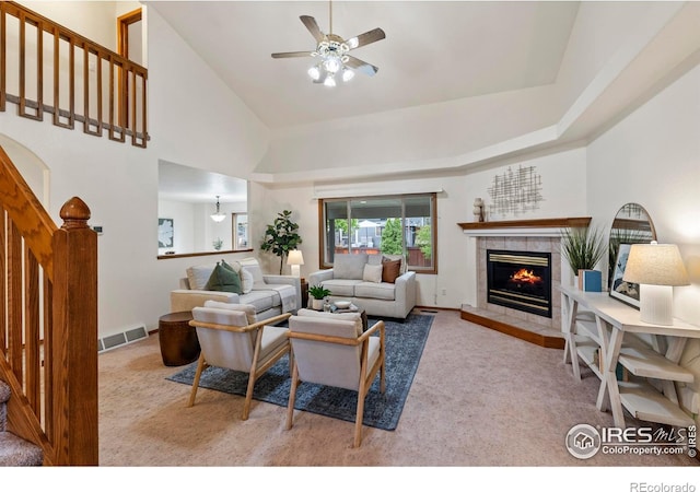 2476 Forsythia Dr, Loveland, CO 80537 - living area featuring visible vents, ceiling fan, stairway, a tiled fireplace, and carpet flooring