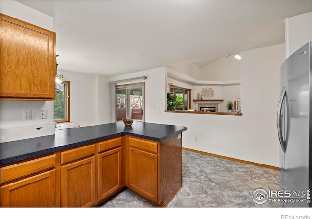 2476 Forsythia Dr, Loveland, CO 80537 - kitchen featuring dark countertops, freestanding refrigerator, a peninsula, and brown cabinetry