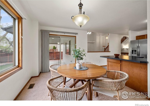 2476 Forsythia Dr, Loveland, CO 80537 - dining space with baseboards, visible vents, light carpet, and stairway