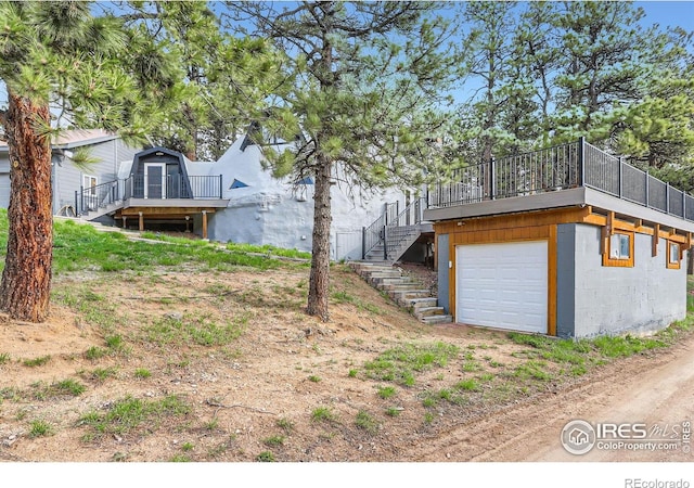 387 Millionaire Dr E, Boulder, CO 80302 - view of yard with stairway, a garage, a deck, and dirt driveway