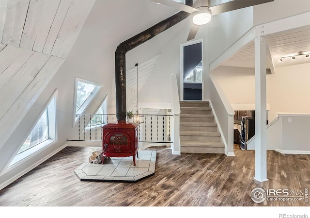 387 Millionaire Dr E, Boulder, CO 80302 - living room with a wood stove, wood finished floors, stairway, a ceiling fan, and baseboards