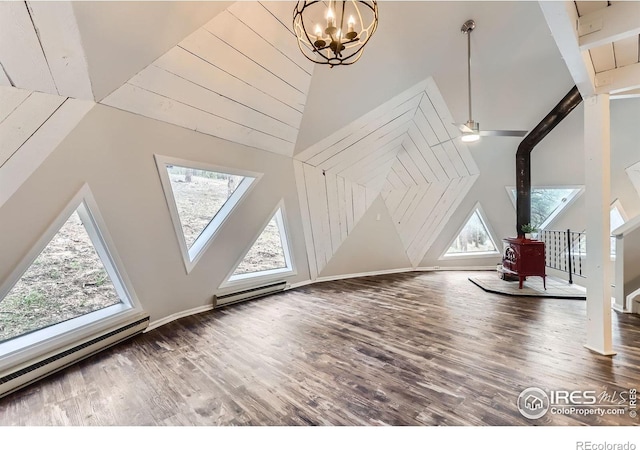 387 Millionaire Dr E, Boulder, CO 80302 - additional living space featuring a wood stove, a wealth of natural light, wood finished floors, and a baseboard heating unit
