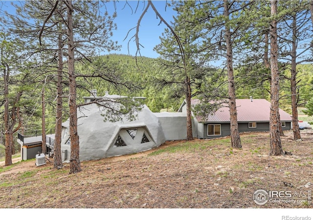 387 Millionaire Dr E, Boulder, CO 80302 - back of property with a wooded view and metal roof