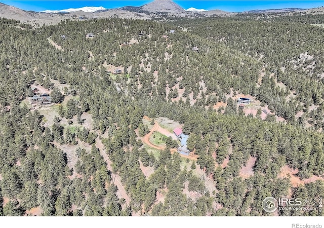 387 Millionaire Dr E, Boulder, CO 80302 - aerial overview of property's location featuring a mountainous background and a heavily wooded area