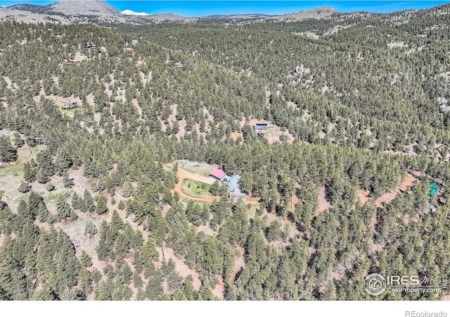 387 Millionaire Dr E, Boulder, CO 80302 - aerial view of property and surrounding area featuring a mountain backdrop and a heavily wooded area