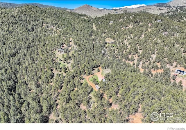387 Millionaire Dr E, Boulder, CO 80302 - aerial view of property and surrounding area featuring a heavily wooded area and mountains
