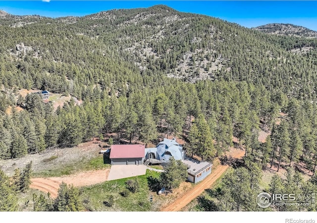 387 Millionaire Dr E, Boulder, CO 80302 - aerial view of property and surrounding area featuring a heavily wooded area and a mountain backdrop