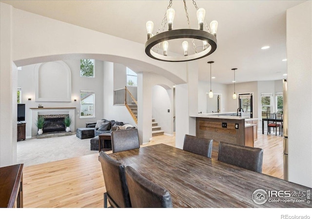 8355 Louden Circle Ft, Collins, CO 80528 - dining space featuring arched walkways, stairway, an inviting chandelier, recessed lighting, and light wood-style flooring