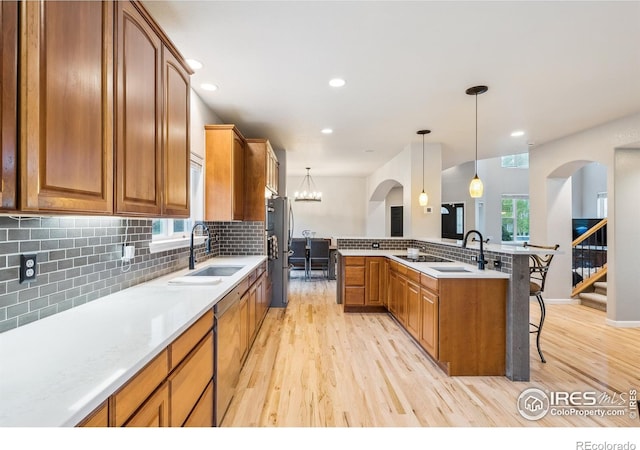 8355 Louden Circle Ft, Collins, CO 80528 - kitchen with a sink, tasteful backsplash, light wood finished floors, and a kitchen bar