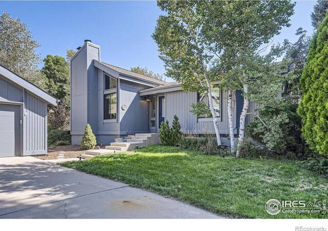 912 Sailors Reef Ft, Collins, CO 80525 - view of front of home with a front lawn, driveway, a garage, and a chimney