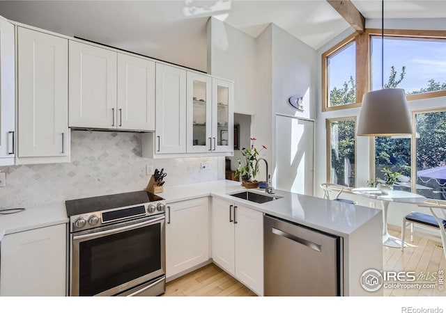 912 Sailors Reef Ft, Collins, CO 80525 - kitchen with stainless steel appliances, a sink, light wood finished floors, white cabinets, and tasteful backsplash