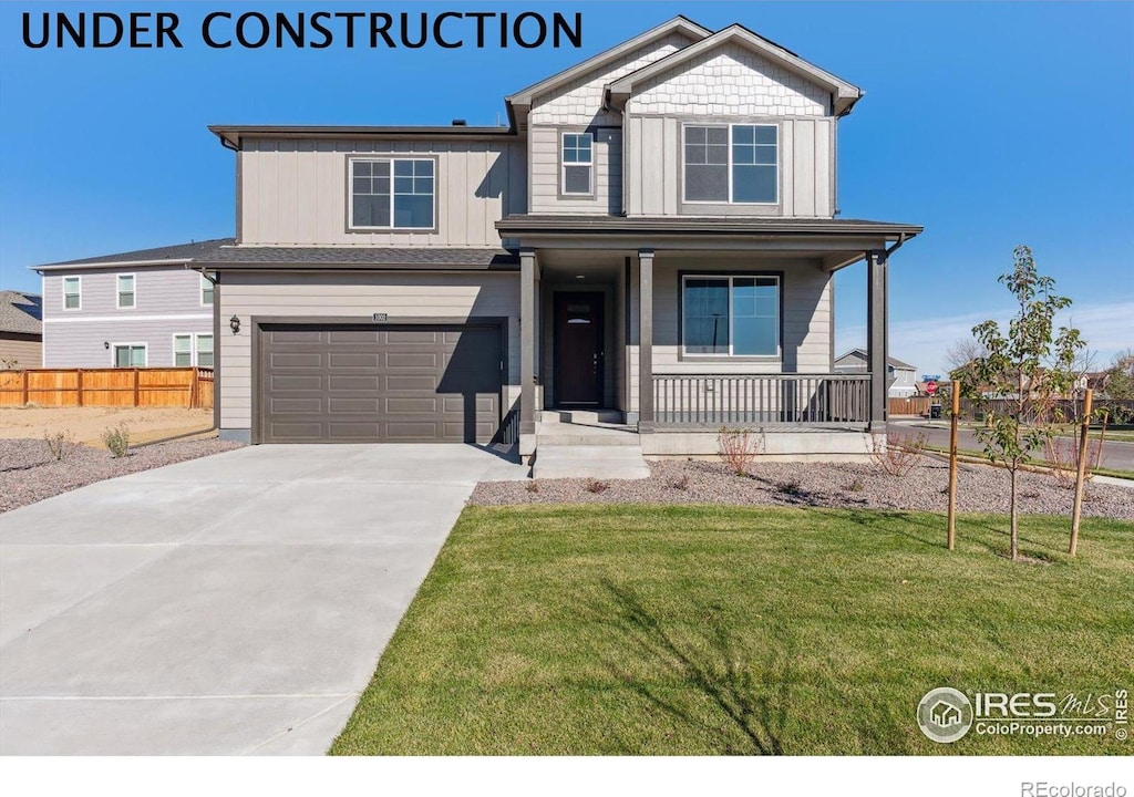 5945 Amerifax Dr, Windsor, CO 80528 - view of front of house with a porch, driveway, a front yard, a garage, and fence