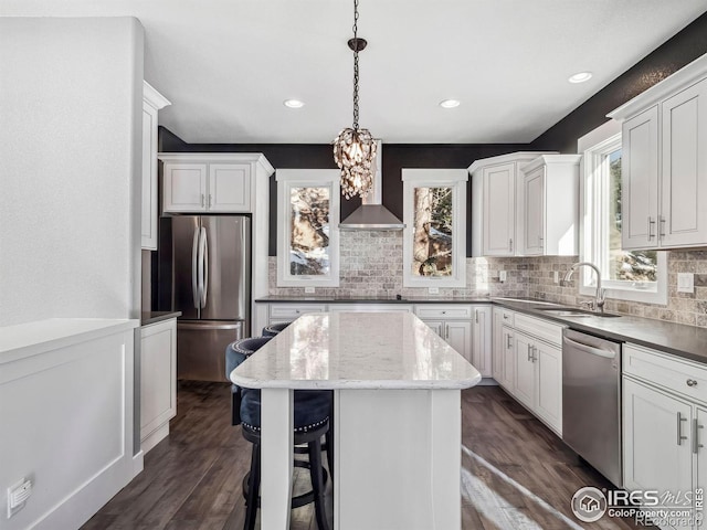 kitchen featuring a center island, a sink, appliances with stainless steel finishes, and backsplash