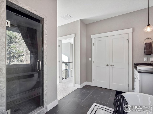bathroom with visible vents, vanity, tile patterned floors, a freestanding bath, and a shower stall