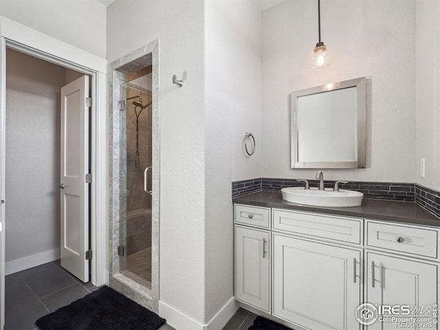 bathroom with vanity, baseboards, tile patterned flooring, and a shower stall