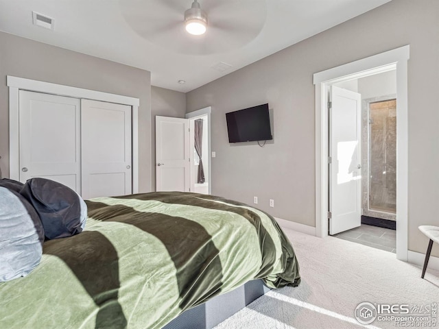 carpeted bedroom with a ceiling fan, visible vents, baseboards, a closet, and ensuite bath