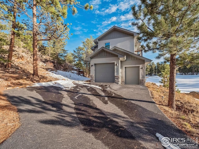 view of home's exterior with a garage, driveway, and stone siding