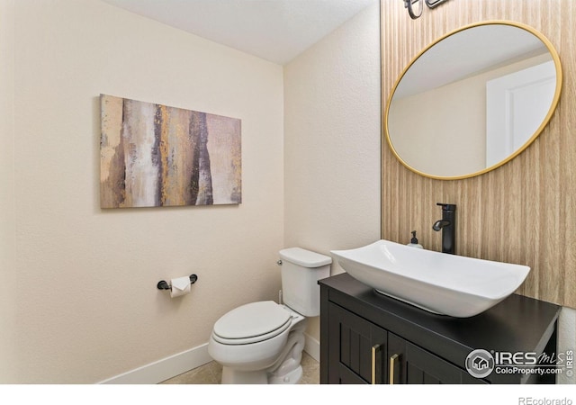 bathroom with toilet, baseboards, tile patterned floors, and vanity