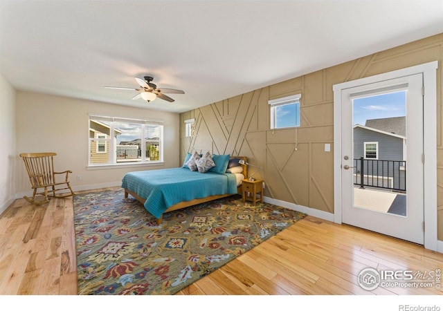 bedroom featuring baseboards, access to outside, light wood-type flooring, and ceiling fan
