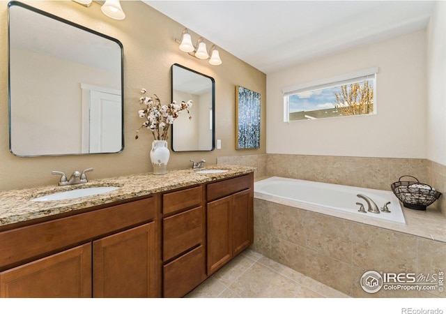 full bath with a sink, tile patterned floors, double vanity, and a bath