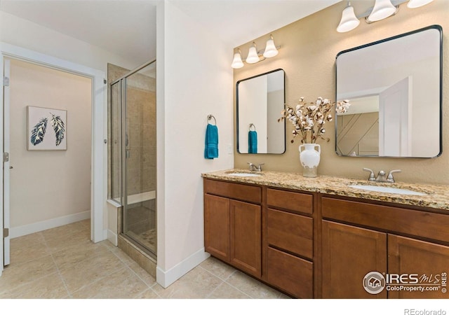full bathroom featuring baseboards, a shower stall, and a sink