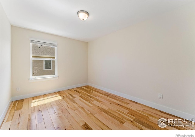 empty room featuring baseboards and wood finished floors