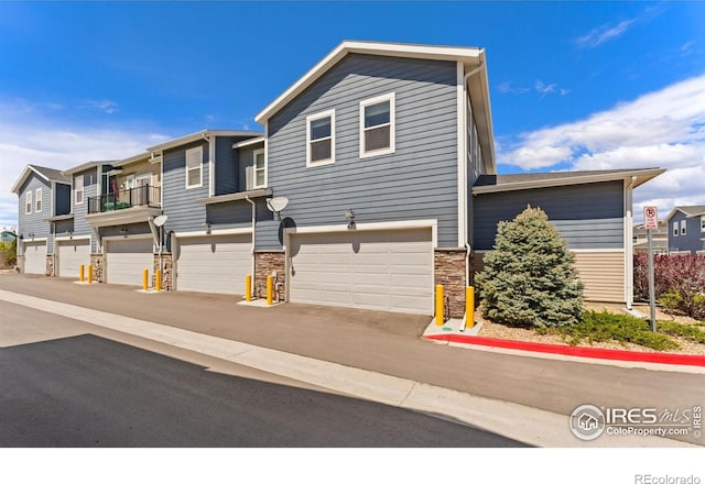 view of front of property with an attached garage and stone siding