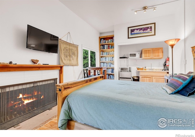 2345 Point Of Pines Dr, Boulder, CO 80302 - bedroom with wood finished floors, indoor wet bar, a sink, and a fireplace
