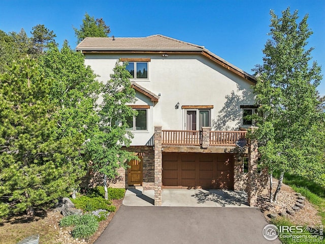 27921 Alabraska Ln, Evergreen, CO 80439 - view of front of property featuring stucco siding, asphalt driveway, and an attached garage