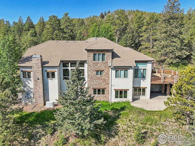27921 Alabraska Ln, Evergreen, CO 80439 - back of property featuring a patio, stucco siding, a wooded view, and stone siding