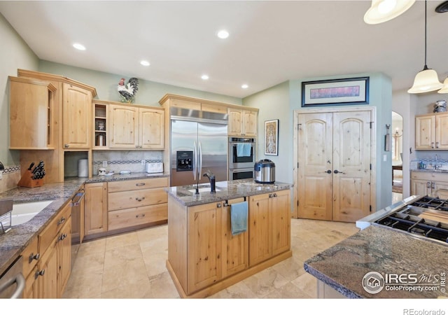 27921 Alabraska Ln, Evergreen, CO 80439 - kitchen with light brown cabinetry, stainless steel appliances, a center island with sink, recessed lighting, and decorative backsplash