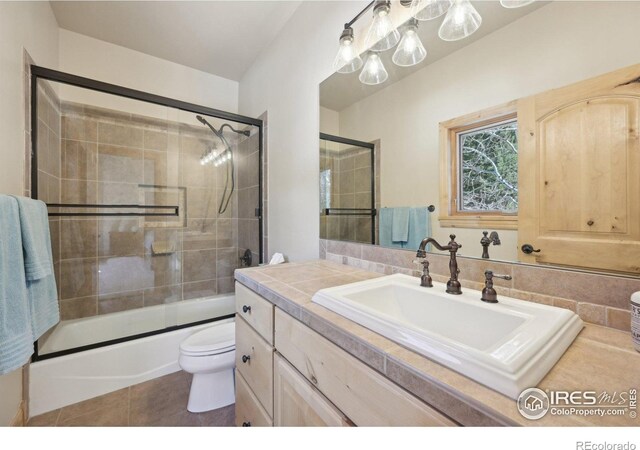 27921 Alabraska Ln, Evergreen, CO 80439 - full bath featuring vanity, combined bath / shower with glass door, and tile patterned floors