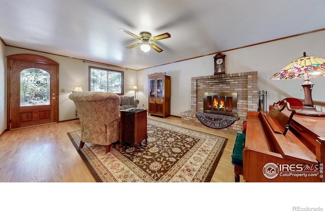 729 Jay Pl, Berthoud, CO 80513 - living area with crown molding, a ceiling fan, light wood finished floors, and a brick fireplace