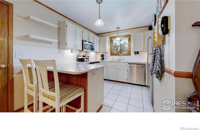 729 Jay Pl, Berthoud, CO 80513 - kitchen featuring decorative backsplash, pendant lighting, appliances with stainless steel finishes, a sink, and a peninsula