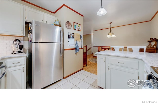 729 Jay Pl, Berthoud, CO 80513 - kitchen with tasteful backsplash, hanging light fixtures, light countertops, freestanding refrigerator, and white cabinetry